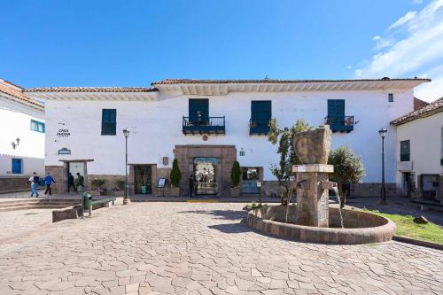 a large white building with a fountain in front of it at Casa Andina Premium Cusco in Cusco