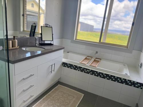 baño con lavabo, bañera y ventana en Alaaya, en Wallan