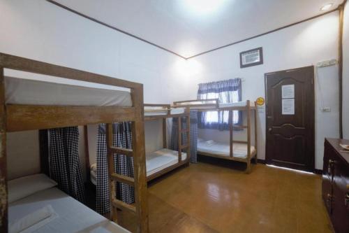 パングラオにあるD' Barn Hostel Panglaoの二段ベッド3組とドアが備わる客室です。