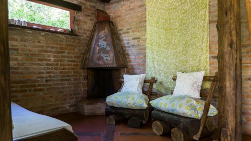 a room with two ottoman chairs and a fireplace at Posada Hale Koa in La Paloma