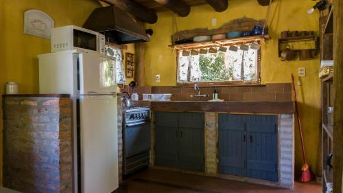 a kitchen with a refrigerator and a sink at Posada Hale Nalu in La Paloma