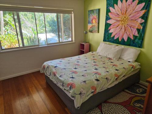 a bedroom with a bed with a flower painting on the wall at Dragonflies on Billa in Point Lookout
