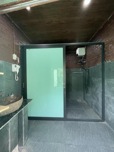 a glass door in a bathroom with a sink at Ba be farmstay in Ba Be18