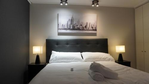 a bedroom with a large white bed with two lamps at Apartamento Pucón in Pucón