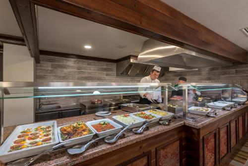two chefs preparing food in a restaurant kitchen at Lion Hotel Borovets in Borovets