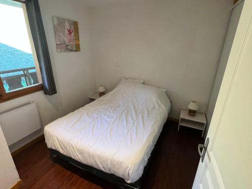 a small bedroom with a white bed and a window at Appartement Montagne 4 Pers, Balcon et Piscine - FR-1-814-162 in Super Besse