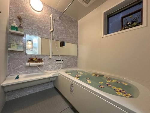 une salle de bain avec une baignoire et un lavabo dans l'établissement nestay house tokyo shinjuku, à Tokyo