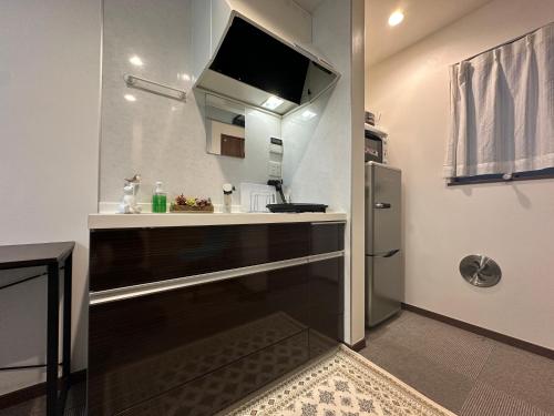 a small kitchen with a sink and a refrigerator at nestay house tokyo shinjuku in Tokyo