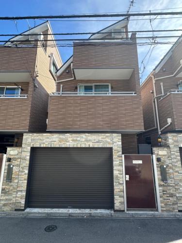a building with a large garage door in front of it at nestay house tokyo shinjuku in Tokyo