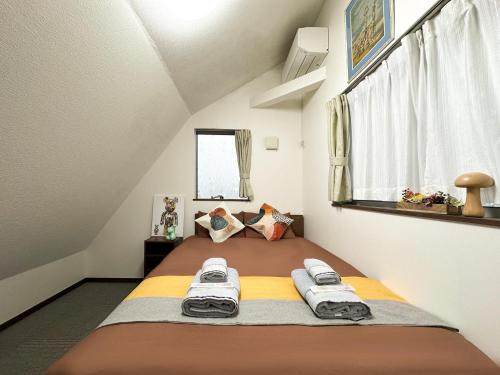 une petite chambre avec un lit dans un grenier dans l'établissement nestay house tokyo shinjuku, à Tokyo