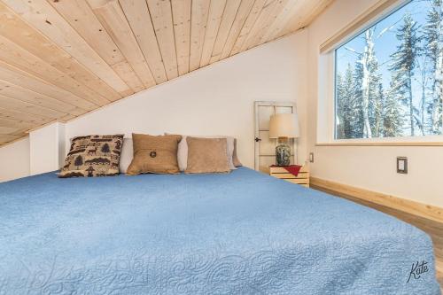 una camera con un letto blu e una grande finestra di Experience Lakeside Cabin Living in North Pole, AK a North Pole
