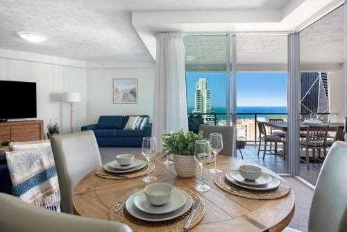 a living room with a table with a view of the ocean at Salinas by the Sea - Hosted by Coastal Letting Co. in Gold Coast