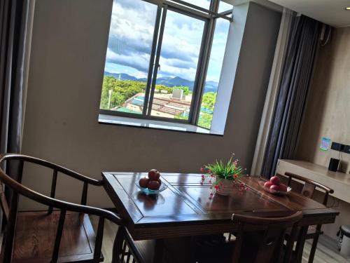 a table and chairs with a window in a room at Wang Tian Shu Value Resort Hotel in Mengla