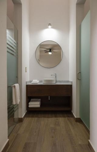 ein Badezimmer mit Waschbecken und Spiegel in der Unterkunft Aura Hotel in Uruapan del Progreso