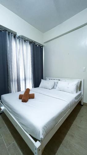 a large white bed with a brown purse on it at 13 Twin Balcony Escape in Iloilo City