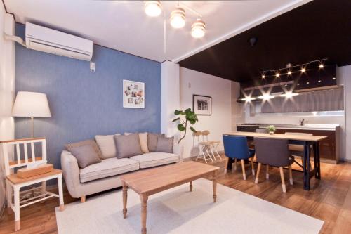 a living room with a couch and a table at Guest House Re-worth Sengencho1 in Nagoya