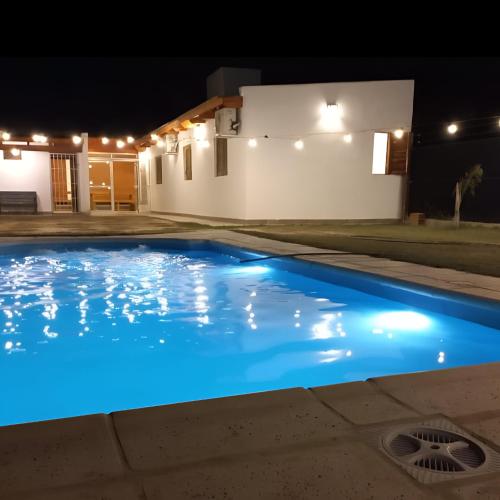 a swimming pool at night with a house in the background at Finca Ayres de Mis Viejos in Maco