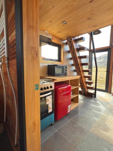 una cocina en una casa pequeña con una escalera en Cabañas Montañas Patagónicas, en Puerto Natales