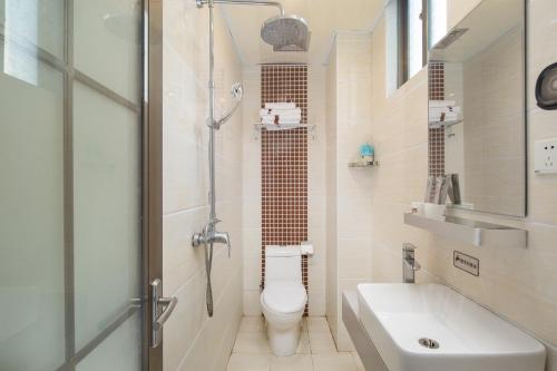 a bathroom with a toilet and a shower and a sink at Thank You Hotel Sanya Bay Coconut Dream Corridor Branch in Sanya