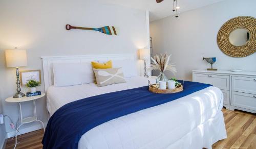 a bedroom with a white bed with a blue blanket at Waterfront Getaway|Fire Pit|Kayaks|Foosball in Seguin