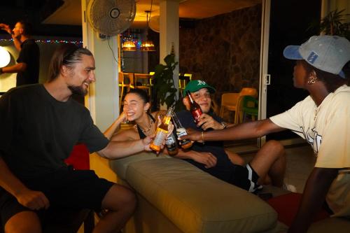 a group of people sitting on a couch drinking beer at El Machico Hostel in Panama City