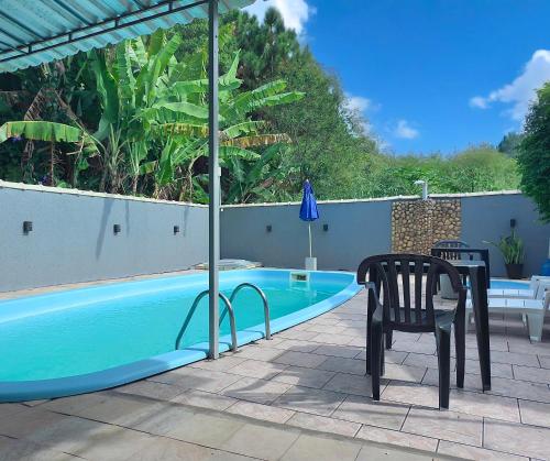 a table and a chair next to a swimming pool at Rede Elevare Ilha do Sol in Florianópolis