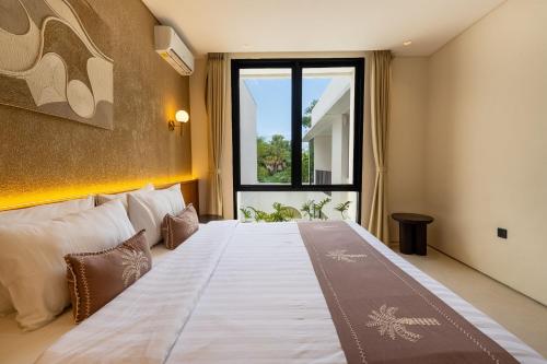 a bedroom with a large bed with a large window at Villa Thre in Mantaak