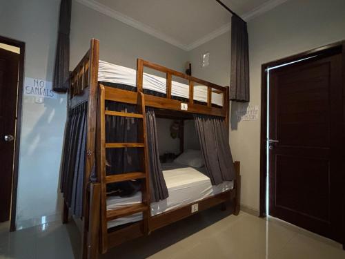 En eller flere senge i et værelse på Suwardika Homestay & Dormitory