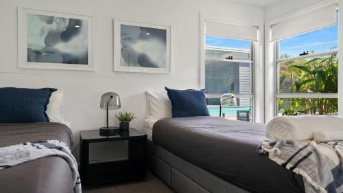 a bedroom with two beds next to a window at The Oasis-Shelly Beach-Private Pool-Golf in Shelly Beach