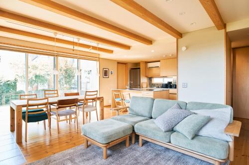 a living room with a couch and a dining room at Kiyose Garden Stay - 最大10名でゆったり過ごせる宿 in Matsuyama
