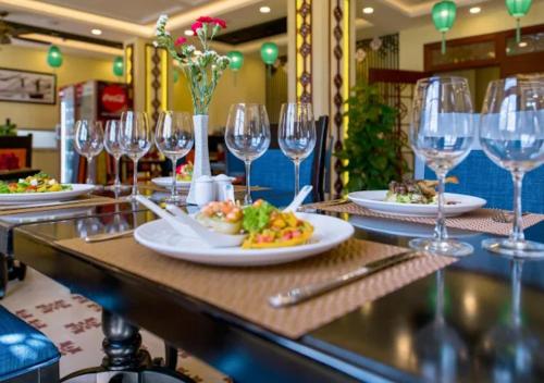 a table with plates of food and wine glasses at My Son Boutique Hotel & Spa Hoi An in Hoi An