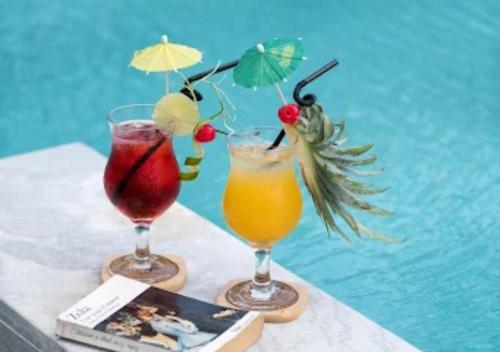 two drinks sitting on a table next to a pool at My Son Boutique Hotel & Spa Hoi An in Hoi An