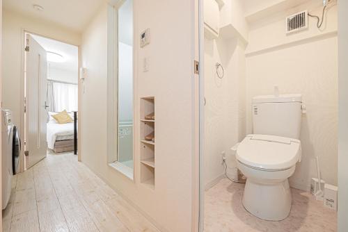 un bagno bianco con servizi igienici e una camera da letto di Japan House Shirokane a Tokyo