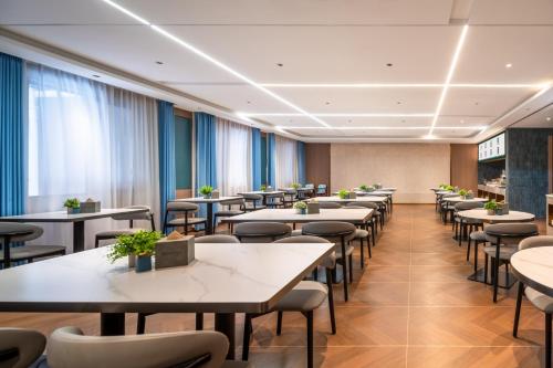 een eetkamer met tafels en stoelen bij Mehood Lestie in Jinghong