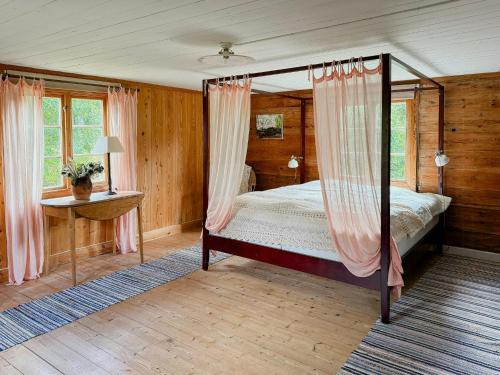 a bedroom with a canopy bed with pink curtains at Historic 19Th Century Cottage In Blekinge in Kyrkhult