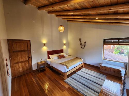 a bedroom with a bed and a wooden ceiling at Flor de Amancay Villas - Sacred Valley in Calca