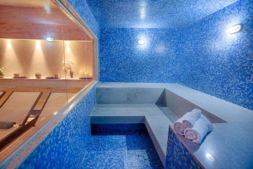 a blue bathroom with a tub and a shower at Alugueasy - Hotel Fusion in Brasilia