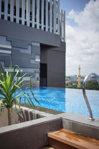 una piscina al costado de un edificio en PORTA by Ambarrukmo, en Yogyakarta