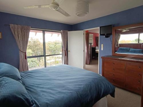 a bedroom with a bed and a large window at Spacious City Apartment With Amazing Views in Christchurch