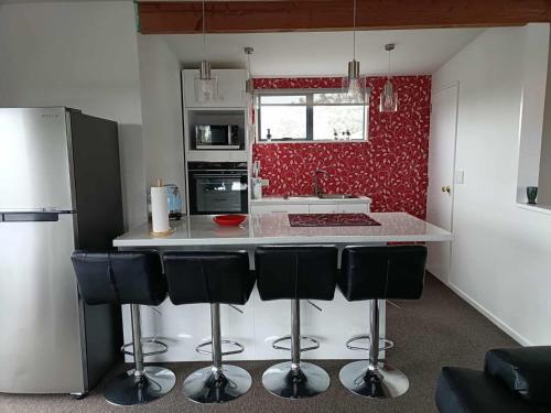 a kitchen with a white counter and black appliances at Spacious City Apartment With Amazing Views in Christchurch