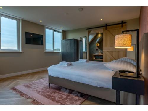 a bedroom with a large bed and a lamp at Modern villa in De Cocksdorp near the beach in De Cocksdorp