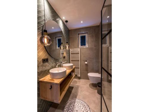 a bathroom with two sinks and a mirror at Modern villa in De Cocksdorp near the beach in De Cocksdorp