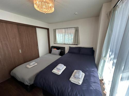 a bedroom with two beds with towels on them at nestay house tokyo shinjuku in Tokyo
