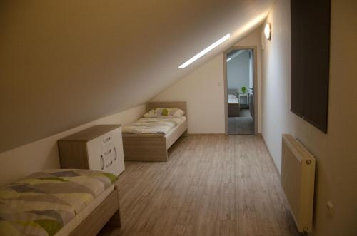a attic room with two beds and a mirror at Apartment Lidická Slavkov, 4 person in Slavkov u Brna