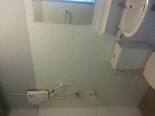 a bathroom with a sink and a mirror and a toilet at A+ Hotel in Ubon Ratchathani
