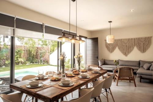 a dining room with a wooden table and chairs at 4BDR Luxury Villa 2 Private Pools 10 min Beach & Zamna in Tulum