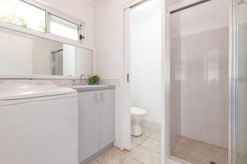 ブルーイーズ・ビーチにあるBlueys Beach Villa Manyana 25の洗面台とシャワー付きの白いバスルーム