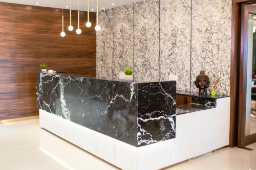 a lobby with a black and white marble counter at Masara Biznotel in Chakan