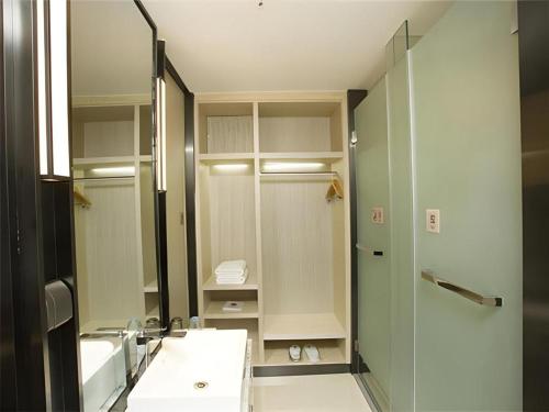 a bathroom with a sink and a mirror at Echarm Hotel Changchun Jiutai District Government Railway Station in Changchun