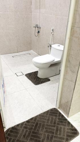 a bathroom with a toilet and a shower stall at شقه مميزه بغرفة نوم وصالة واسعه in Hafr Al Baten